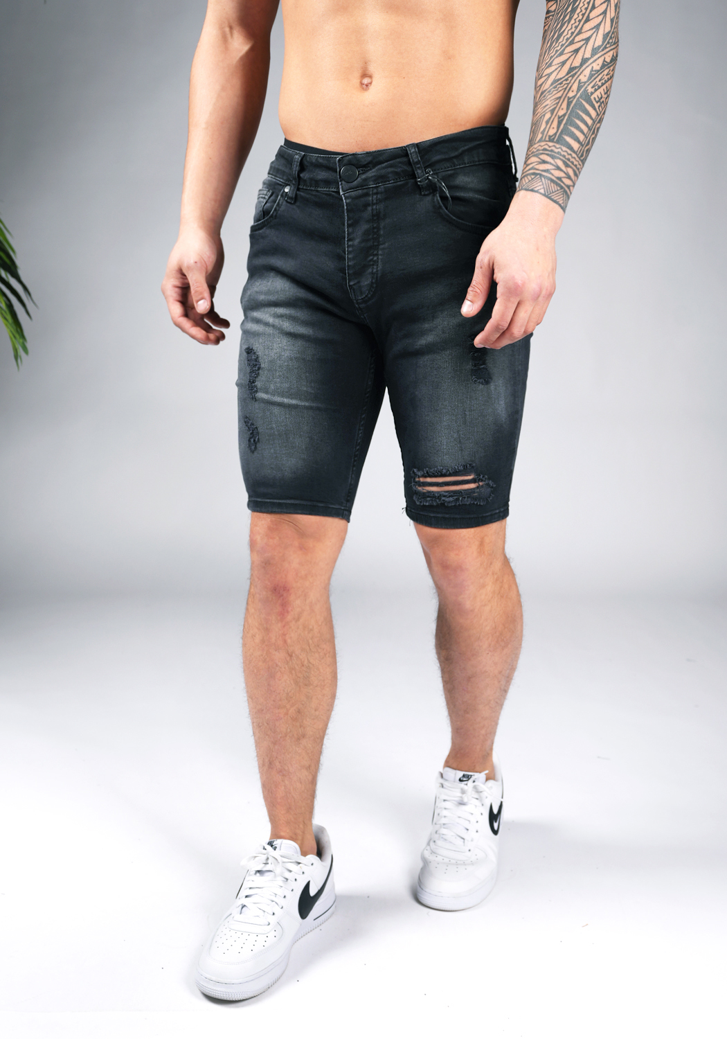 chark shorts 15 Linker vooraanzicht van model gekleed in zwarte jean shorts met damaged details.