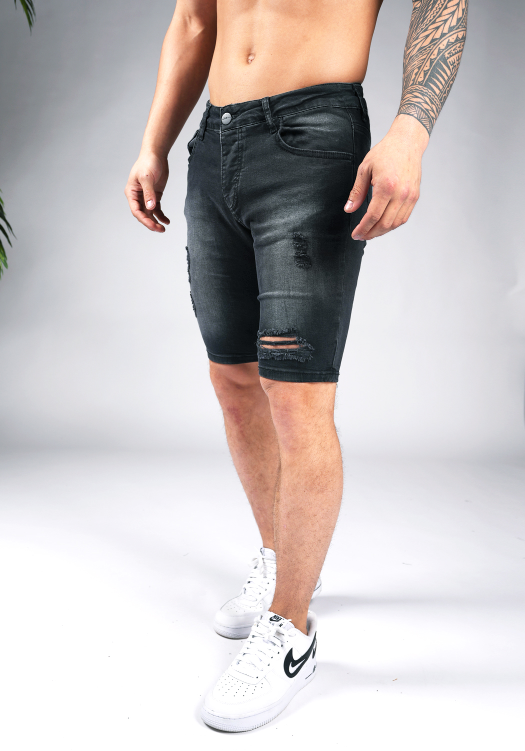 chark shorts 16 Linker schuin vooraanzicht van model gekleed in zwarte jean shorts met damaged details.